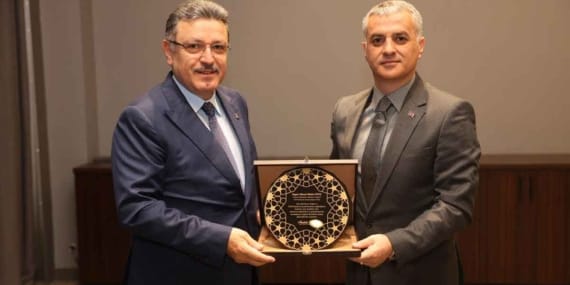 Başkan-Bıyık-Başkan-Genç'e-teşekkür-plaketi-verdi